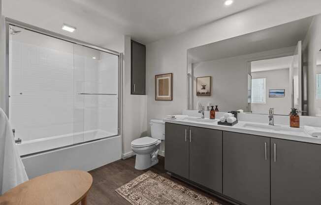 a bathroom with a shower toilet and sink and a mirrorat Westbury Apartments, Rancho Cucamonga, California