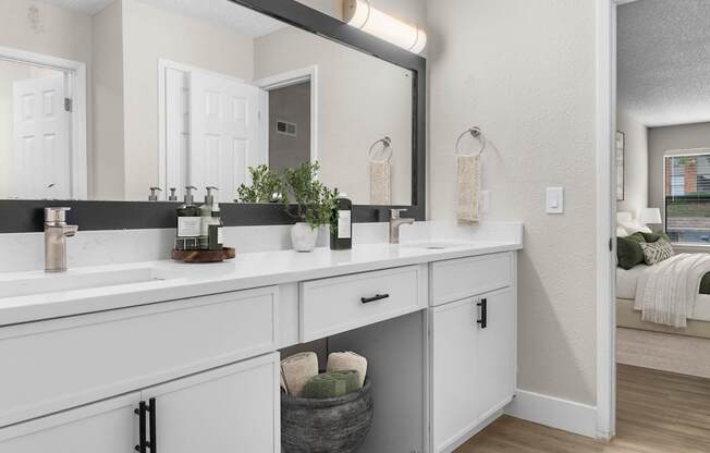 A bathroom with two sinks and a large mirror.