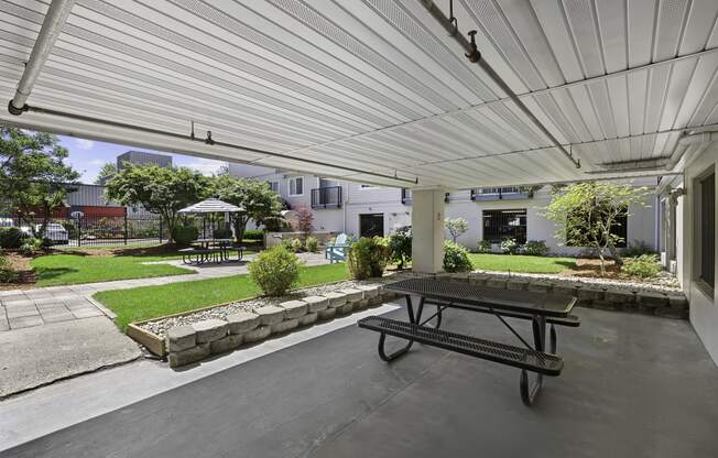 a covered patio with a picnic table and courtyard area in the background at King Arthurs Court, Seattle, 98125