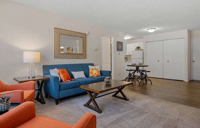 a living room with a blue couch and orange chairs