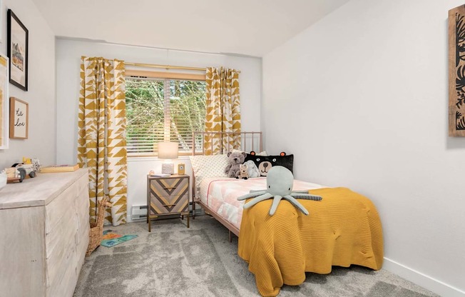 a bedroom with a bed and a window with a yellow curtain