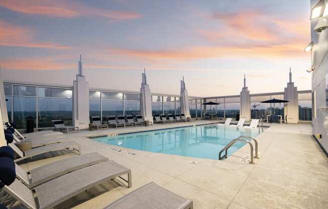 a swimming pool on the roof of a building at sunset