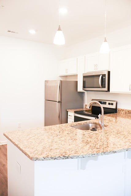 a kitchen with a granite counter top and a stainless steel refrigerator