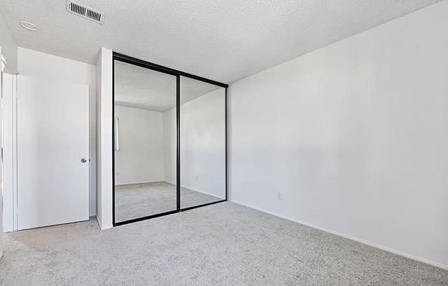 bedroom with carpet and closet with mirrored sliding doors