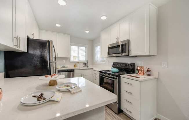 Kitchen with White Countertop, White Cabinets, Microwave and Refrigerator