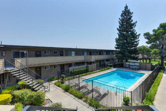 Outdoor Swimming Pool, Trees, Bushes and Apartment Exteriors