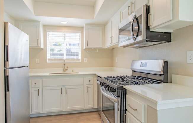 a kitchen with white cabinets and a stove and a refrigerator