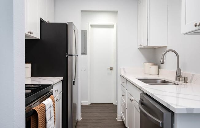 a kitchen with white cabinets and a black refrigerator