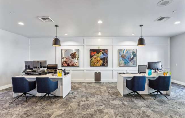 an office with desks and chairs and paintings on the wall