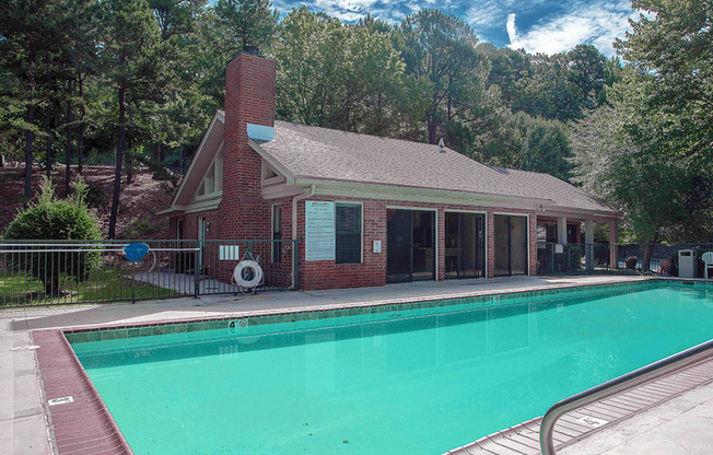 apartment clubhouse with a swimming pool in front of it