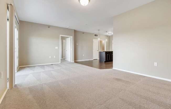 A large, empty room with a carpeted floor and white walls.