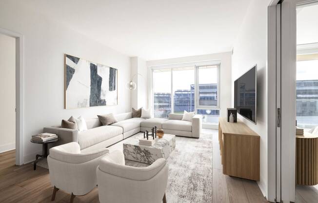 a living room with white furniture and a large window