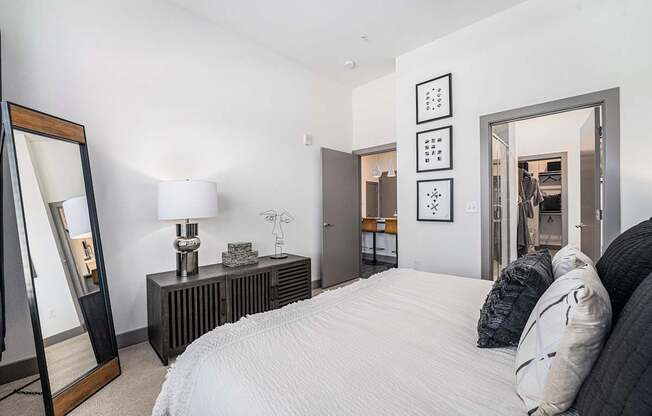 A bedroom with a large bed, a dresser, and a mirror.