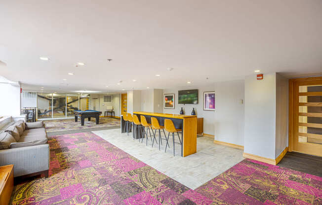 A large room with a pink carpet and a long table with chairs.