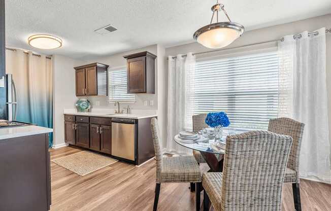 A modern kitchen with a dining table set for two.