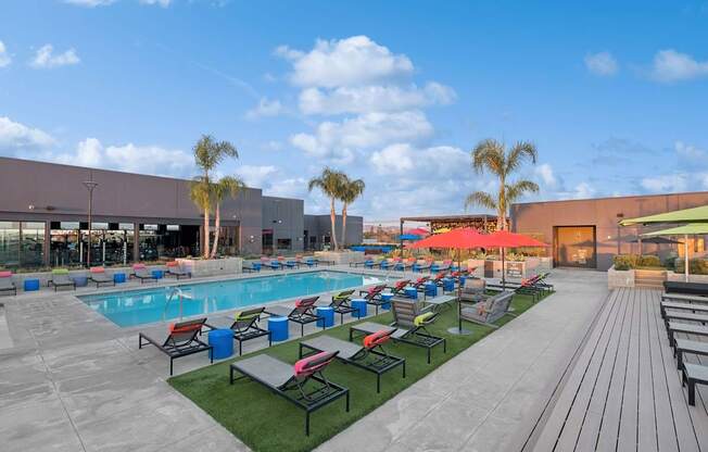 A large outdoor swimming pool area with loungers and umbrellas.