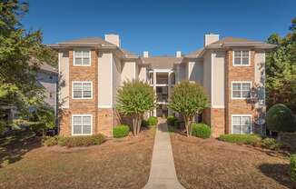 A residential building with a pathway leading to the entrance.
