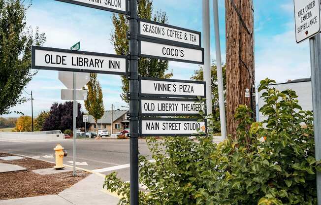 A signpost with multiple directional signs pointing to various local businesses.