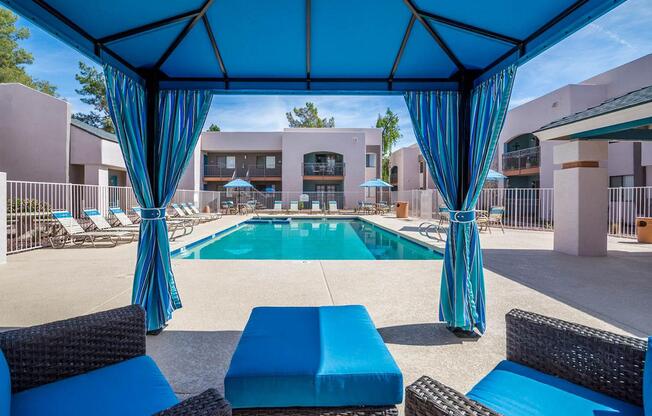 A pool area with blue furniture and a blue canopy.