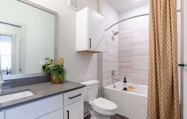 A bathroom with a white toilet, sink, and bathtub.