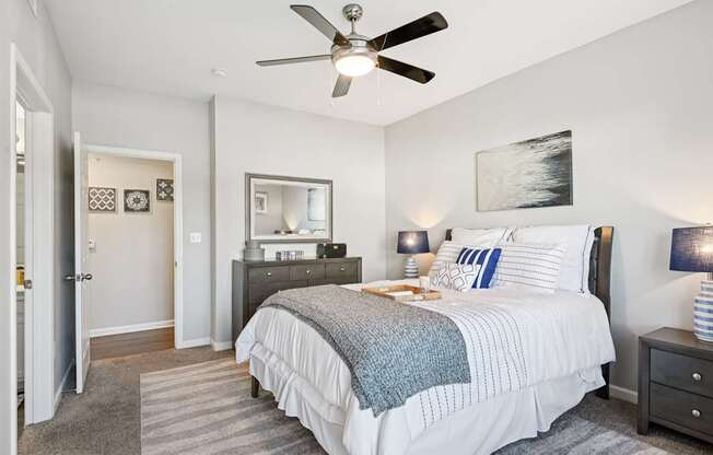 A bedroom with a large bed and a ceiling fan.