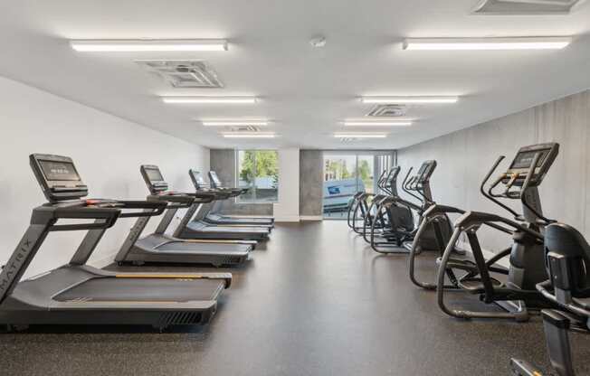 A gym with treadmills and elliptical machines.
