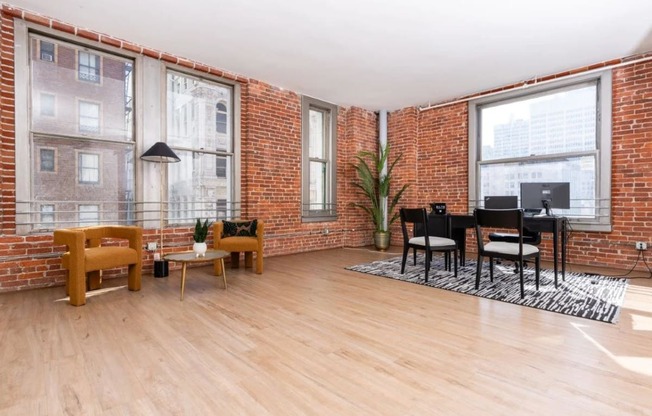 a living room with a piano and a brick wall