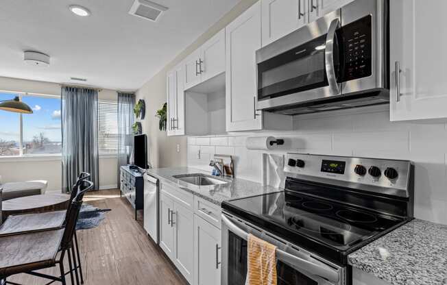 an updated kitchen with white cabinets and stainless steel appliances at Alton Jefferson Park, Denver Colorado