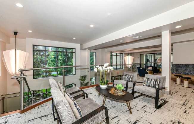 A well-lit living room with a balcony overlooking a garden.