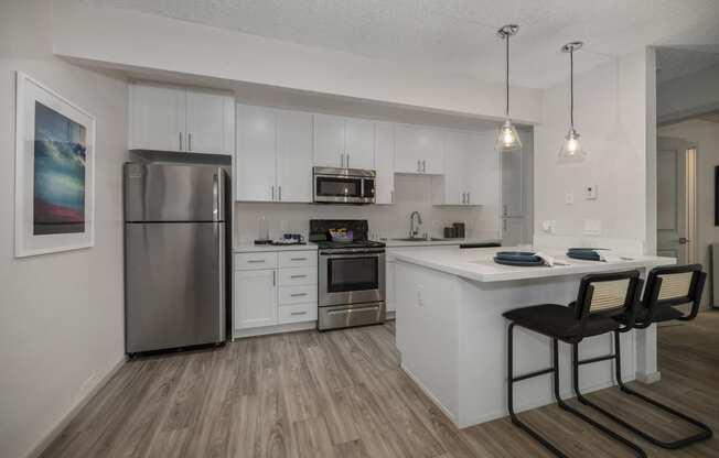 a kitchen with white cabinetry and stainless steel appliances