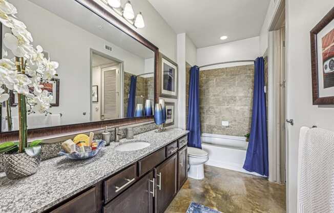 Spacious bathroom with a large mirror and ample counter space at Allusion at West University apartments in Houston, TX