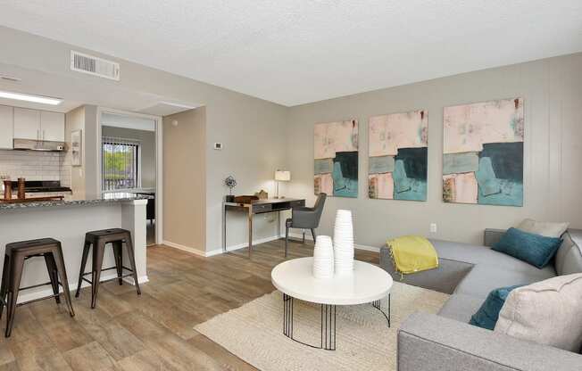 a living room with a couch a table and a kitchen in the background at The Oasis Daytona