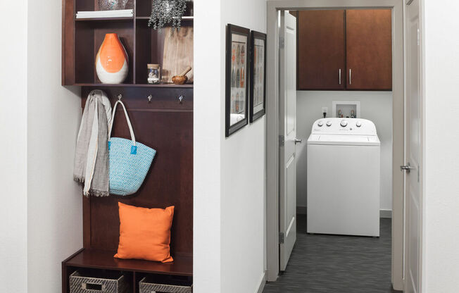 A bathroom with a white sink and a brown cabinet.