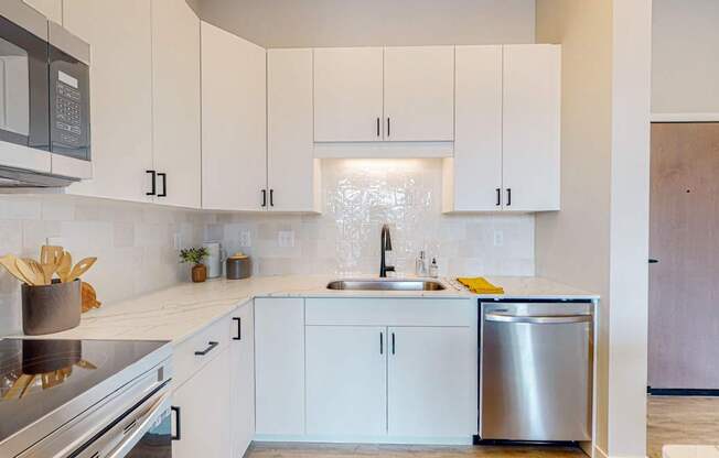 a kitchen with white cabinets and stainless steel appliances