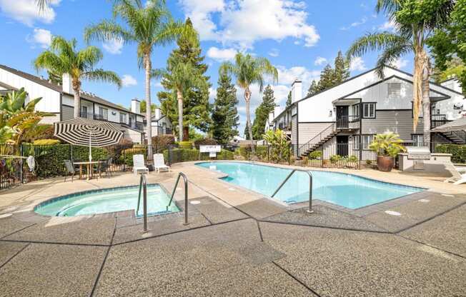 a swimming pool with palm trees and apartments in the background