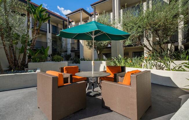 a patio with a table and chairs and an umbrella