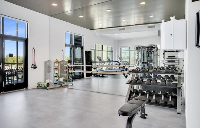 A gym with a variety of equipment including weights and machines.