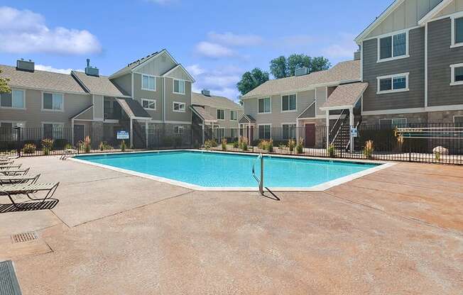 Community Swimming Pool with Pool Furniture at Broadmoor Village Apartments located in West Jordan, UT.