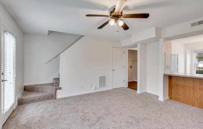 Carpeted Living Room With Stairwell Leading Upstairs