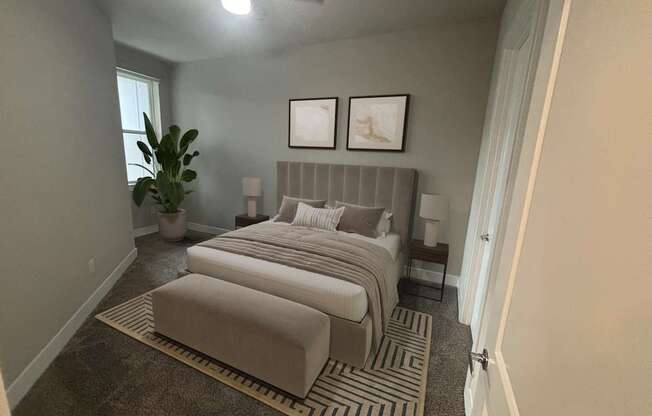 A bedroom with two beds and a plant.