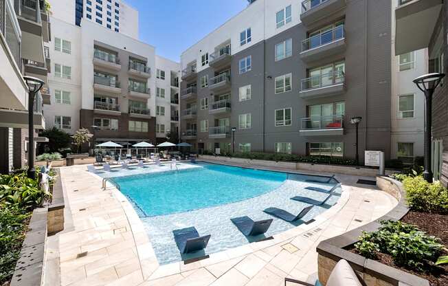 A swimming pool surrounded by buildings and plants.
