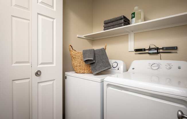 a laundry room with a washer and dryer and a door to the bathroom