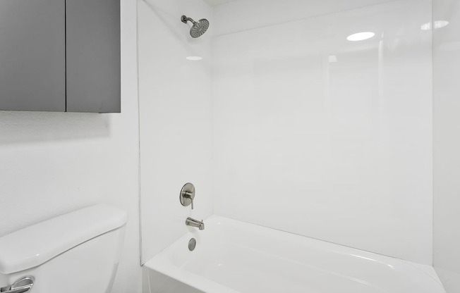 A white bathroom with a toilet, sink, and bathtub.