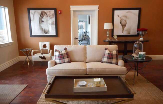 A living room with a couch, coffee table, and two framed pictures on the wall.