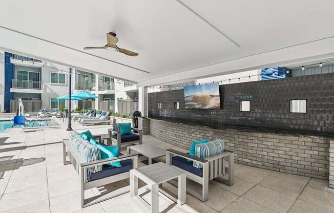A patio with a table and chairs overlooking a pool.