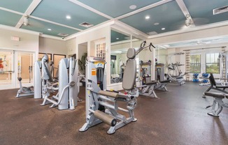 a gym with weights and cardio equipment at the estates apartments