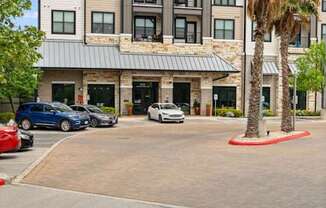 A modern building with a parking lot in front.