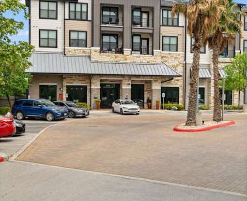 A modern building with a parking lot in front.