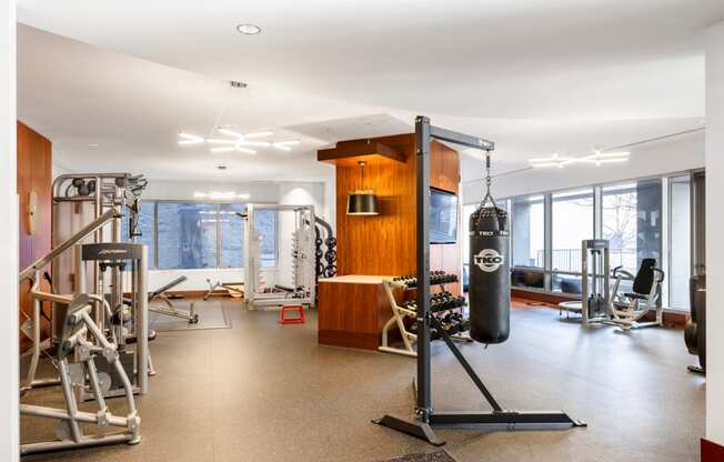 a workout room with weights and a punching bag in front of a window