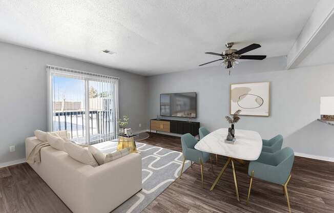 A living room with a white couch, a white coffee table, and a ceiling fan.